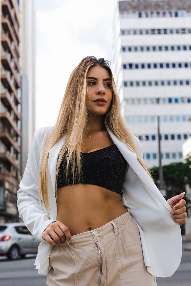 Confident young woman in a chic outfit stands stylishly in an urban Curitiba setting, embodying modern city vibes.